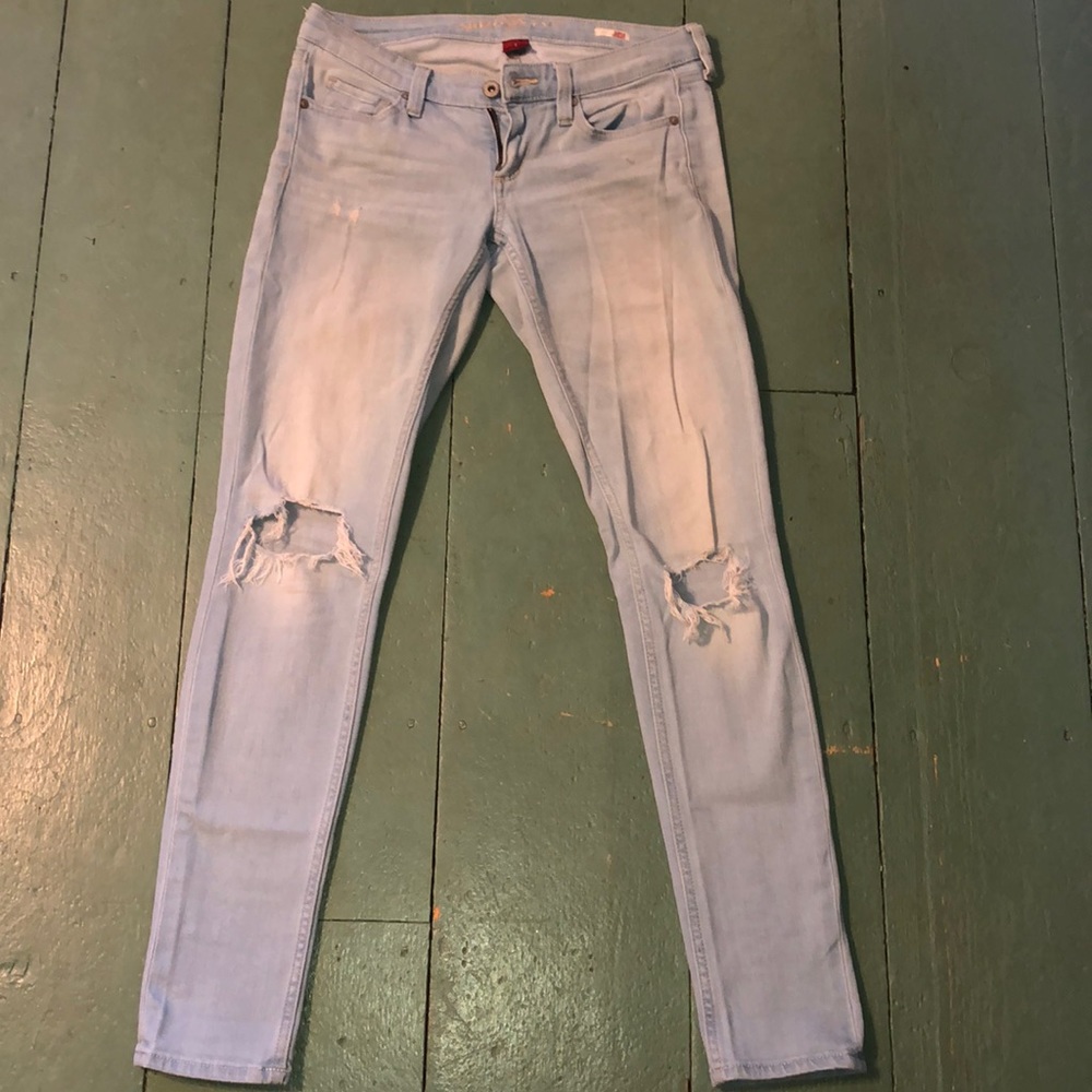 Light blue jeans with holes in the knees.